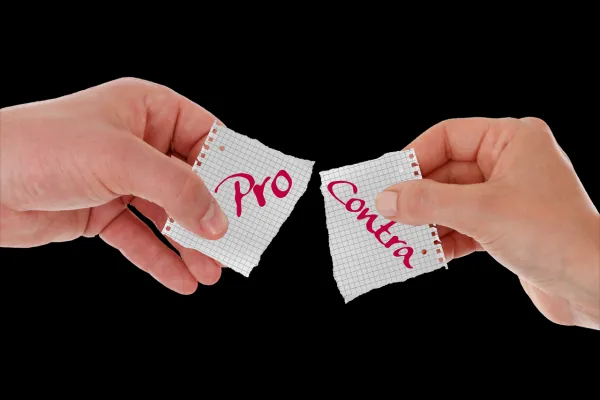 Zwei Hande zerreißen einen Notizzettel - auf der einen Hälfte steht "Pro", auf der anderen "Contra"